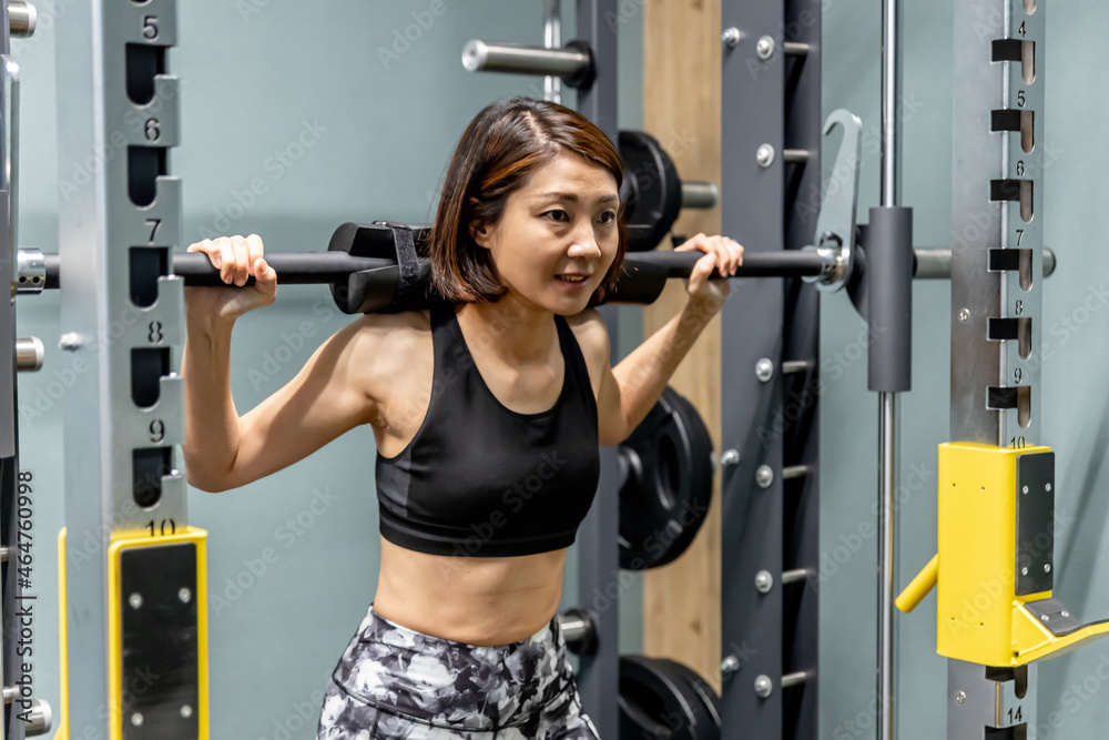 スポーツジムで鍛える女性(スミスマシン)
スポーツジムで鍛える女性(スミスマシン)