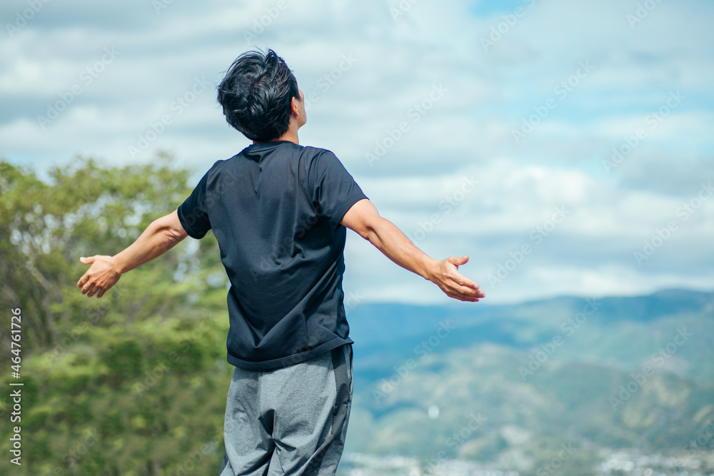 深呼吸する男性(後ろ姿)
深呼吸する男性(後ろ姿)