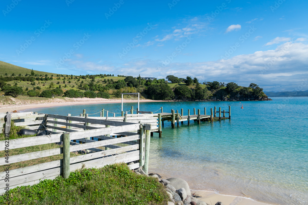 Summertime at the waterfront of a small island near Auckland, New Zealand. Blue sky, blue water, sea, beach, peaceful view.