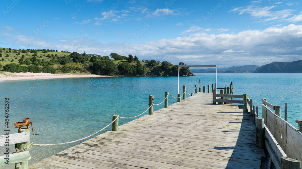 Summertime at the waterfront of a small island near Auckland, New Zealand. Blue sky, blue water, sea, beach, peaceful view.