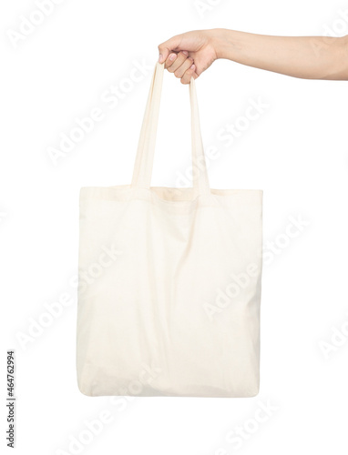 Hand holding canvas tote bag mockup used as design template, isolated on white background with clipping path.