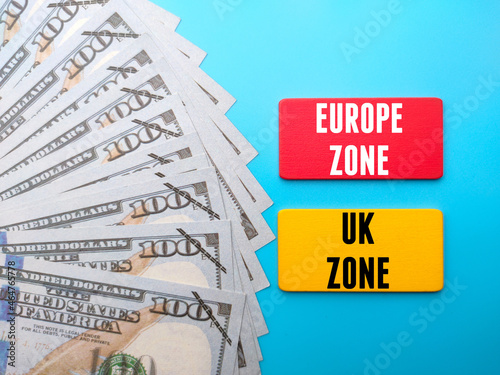 Banknotes and colored wooden board written with text EUROPE ZONE UK ZONE. Business concept. © Mohd Azrin
