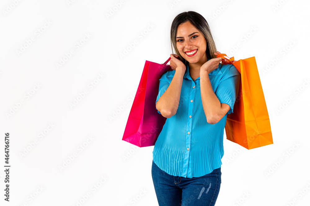 Beautiful young woman looking forward with a happy expression and colorful shopping bags in both hands. Copy space. Beautiful young woman looking forward with a happy expression and colorful shopping bags in both hands. Copy space.