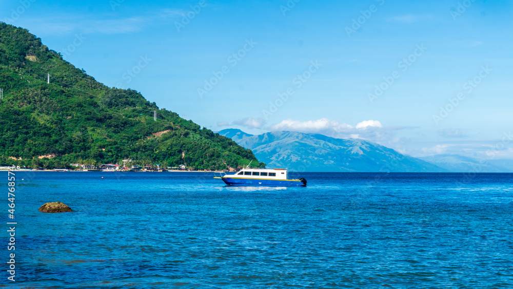 Tropical beach view with a boat in Puerto Galera, Mindoro Island, Philippines.  Travel and landscapes.