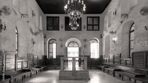 Black and white shot of interior of historic Jewish Maimonides Synagogue or Rav Moshe Synagogue with altar, arched windows and chandelier in Gamalia district, Cairo Egypt photo