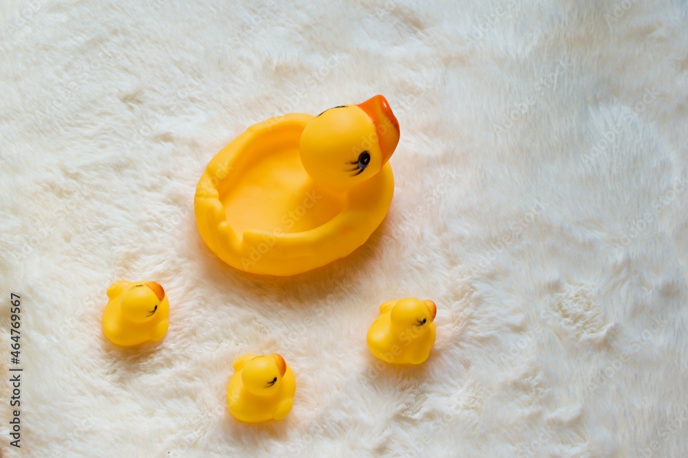 cute toy yellow rubber duck on white fur texture background family concept cute toy yellow rubber duck on white fur texture background family concept
