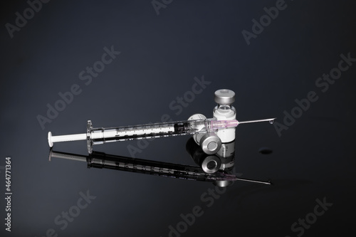Syringe with vials and Needle on dark background
