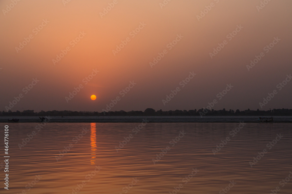 Naklejka premium インド ヴァラナシの早朝のガンジス川と朝日でオレンジ色に染まった空