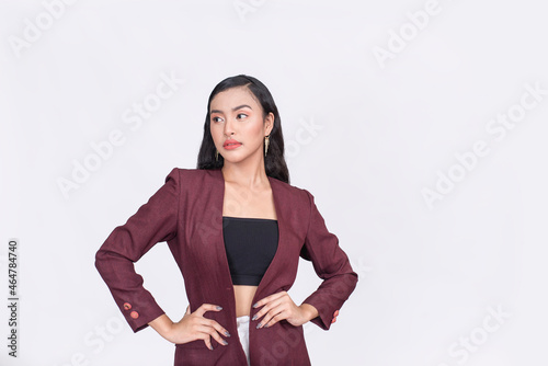 A pretty asian woman in a plum blazer and black tube top modeling. Hands on waist. Isolated on a white background. photo