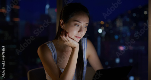 Woman use of tablet computer at night inside the room