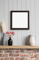 Blank picture frame mockup on gray wall. Modern living room design. View of loft style interior with artwork mock up on wall. Home staging and minimalism concept