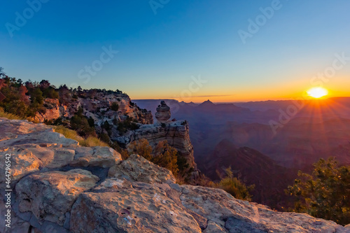 Sunrise at Grand Canyon, Colorado, USA, photographed from a viewpoint in late summer. The golden hue of the rising sun is reflected on the different layers of rocks formed over millions of years. 