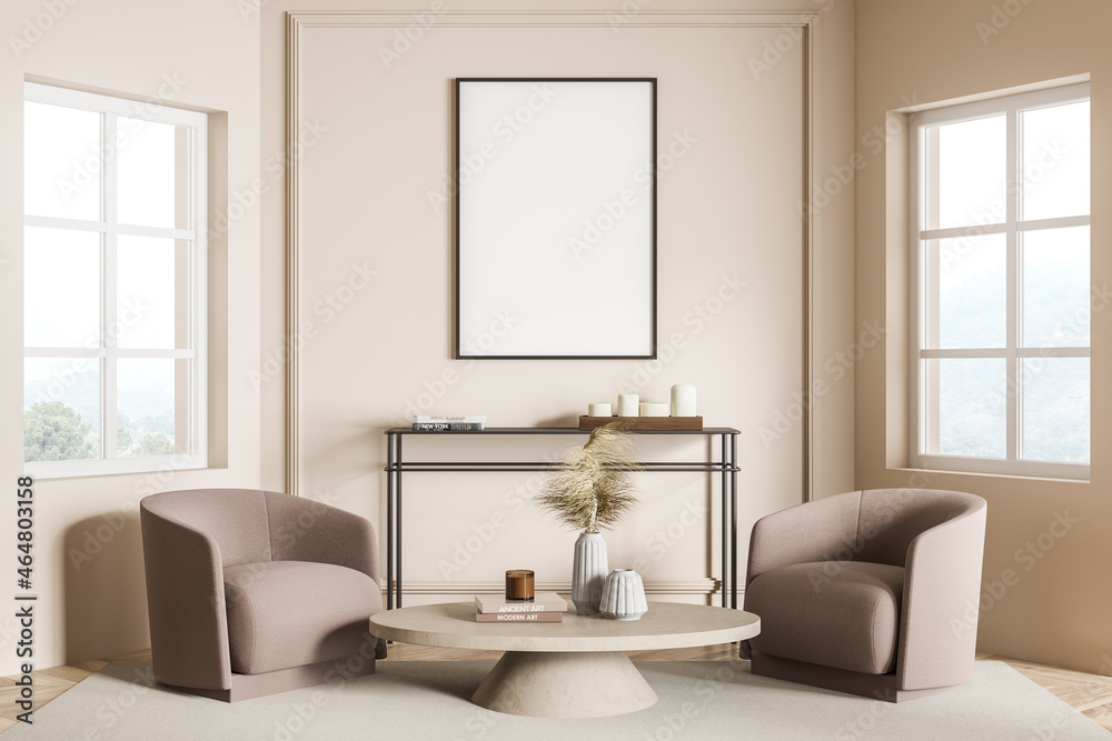 Fototapeta premium Empty frame on beige living room wall and two armchairs. Seating idea