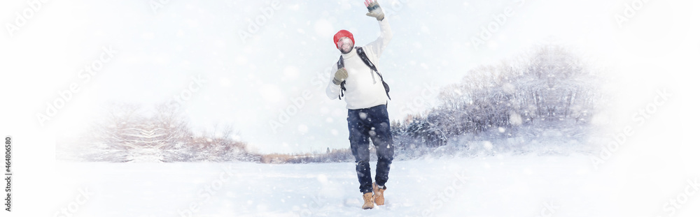 A man travels with a backpack. Winter hike in the forest. Tourist on a walk in the winter in the park. A man travels with a backpack. Winter hike in the forest. Tourist on a walk in the winter in the park.