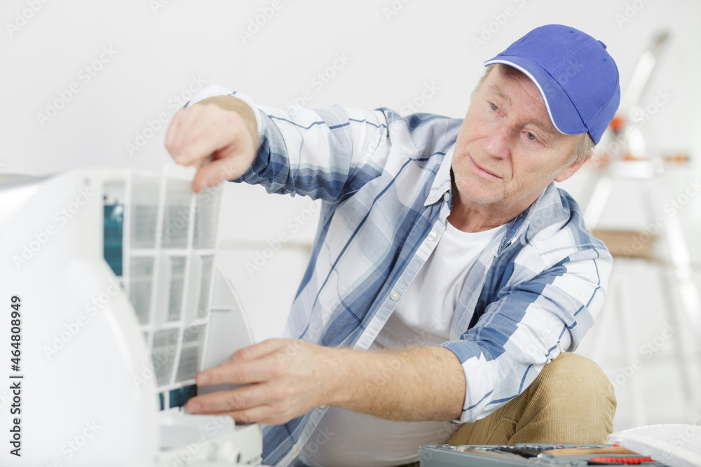 technician repairing air conditioner at home technician repairing air conditioner at home