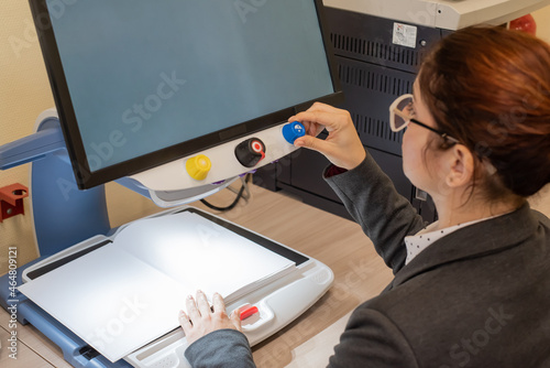 A visually impaired woman uses special reading equipment photo