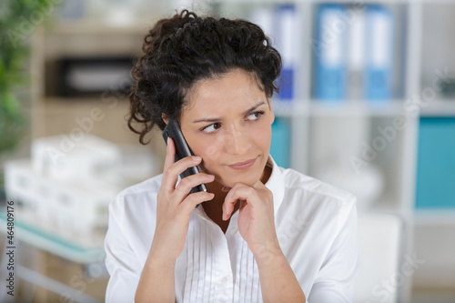 suspicious woman holding phone on a sofa photo