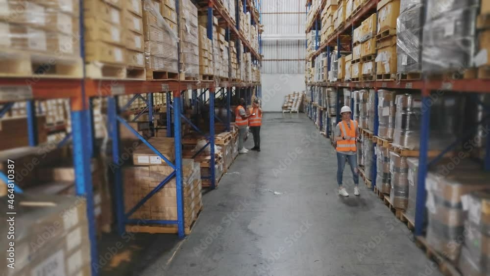 Group of warehouse staff  colleague or worker working together checking shipping stock at depot or distribution center store, High angle crane shot