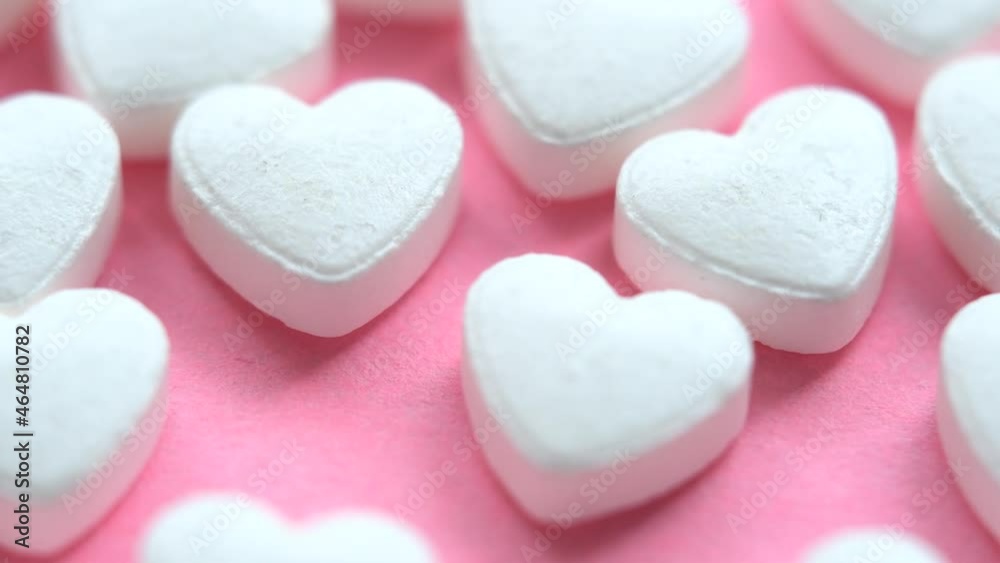 Pink background with heart shaped medical pills. Heart and cardiovascular medications. Substrate on the topic of medicine and health. Pink background with heart shaped medical pills. Heart and cardiovascular medications. Substrate on the topic of medicine and health.