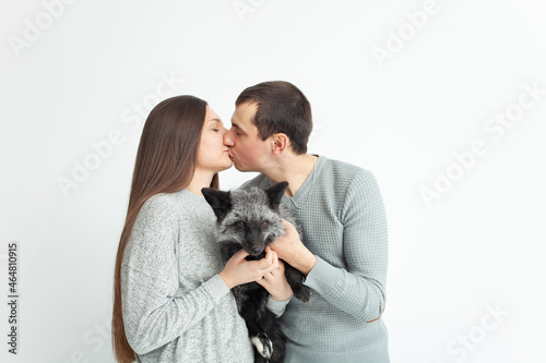happy family isolates on a white background, smiling, hugging, kissing. Concept, lifestyle. brown fox, new family member, mom and dad