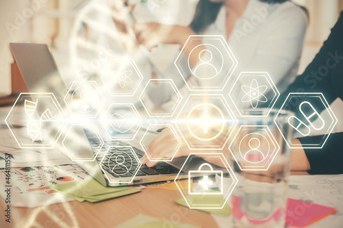 Double exposure of woman hands typing on computer and DNA hologram drawing. Medical education concept.