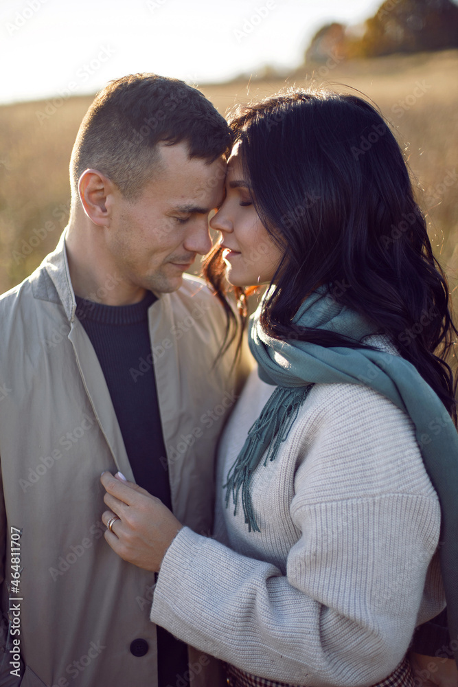 couple of a man with a woman in a field with dry grass at sunset couple of a man with a woman in a field with dry grass at sunset