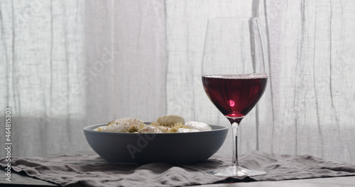 red wine in wineglass with pasta on background