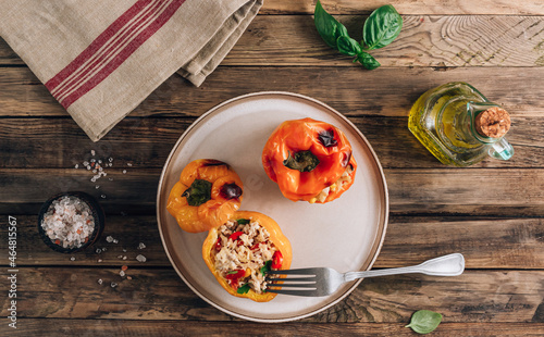 Colorful bell stuffed paprika peppers with meat, rice and vegetables on wooden background