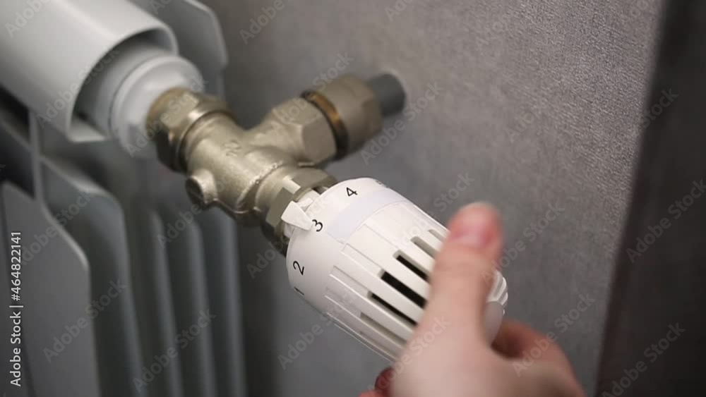 Person adjusts the temperature of the battery radiator at home, close-up slow motion footage Person adjusts the temperature of the battery radiator at home, close-up slow motion footage