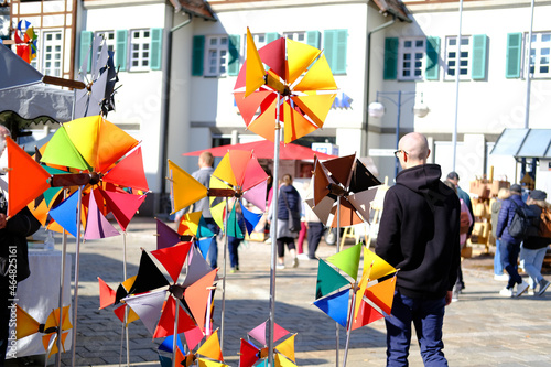 fair at the market square in the city center, artisans sell self-made goods, shoppers stroll through the sunny city, windmills and other goods of people creating and making handicrafts from all sides photo