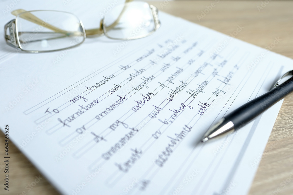 close-up of glasses and a ballpoint pen on paper with a written will, the concept of a legal order on her movable and immovable property in the event of a person's death for the heirs close-up of glasses and a ballpoint pen on paper with a written will, the concept of a legal order on her movable and immovable property in the event of a person's death for the heirs