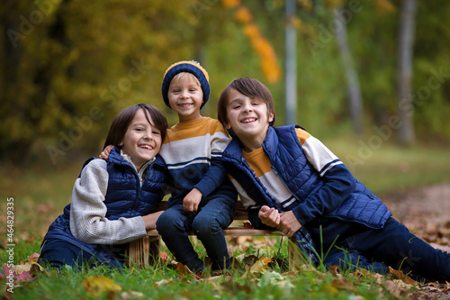 Happy family, funny children, having their autumn pictures taken in the park, playing