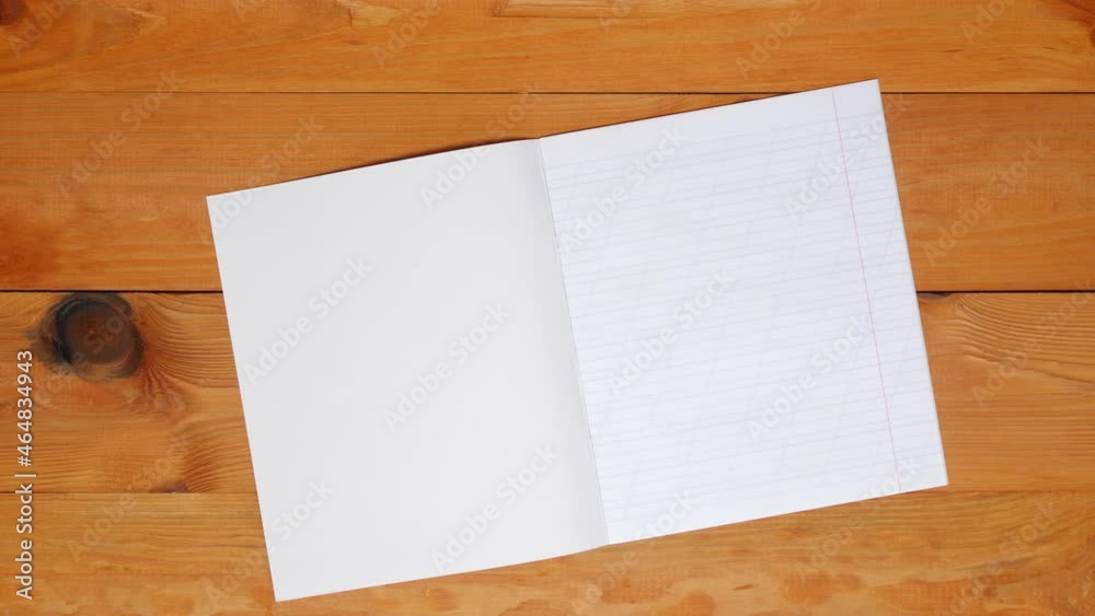 School teacher lays out a notebook in an oblique line, colored pens and the alphabet for learning spelling on a wooden table in the preschool classroom. Blank sheet page. Copy space for text. Top view