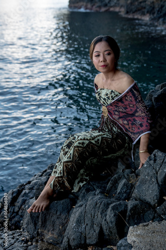 Balinese girl posing in nature and in a on the coast Candidasa's offshore islands in Bali, dressed in a traditional costume. 