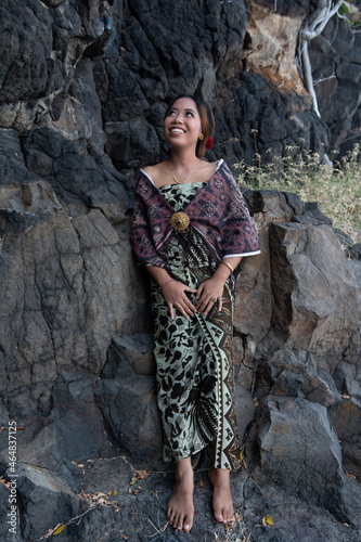 Balinese girl posing in nature and in a forest on Candidasa's offshore islands in Bali, dressed in a traditional costume. 