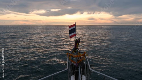 View from scuba diving prow boat with Thai flag on the bow and garland for worship Speedy transport in outdoor tourism in Andaman Sea, beautiful natural landscape, sea sunset or sunrise sky. photo