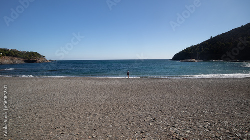 Fényképezés lonely woman on a sunny beach, femme solitaire sur la plage de Port Bou