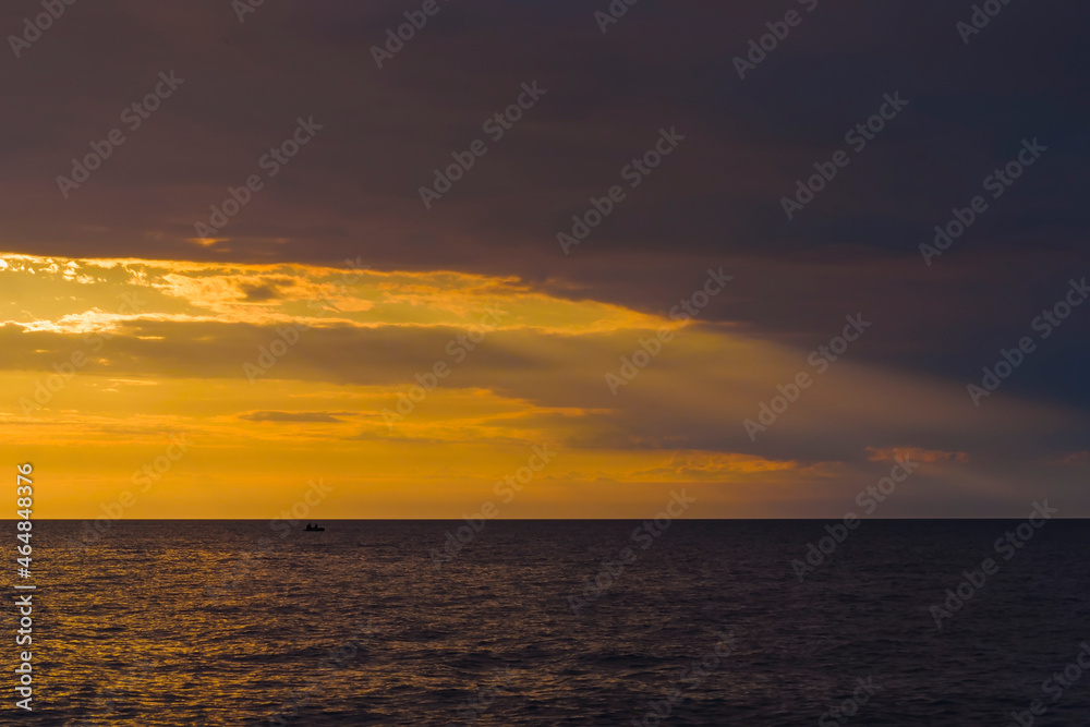 Beautiful summer sunset over the baltic sea. The sun rays pass through the clouds