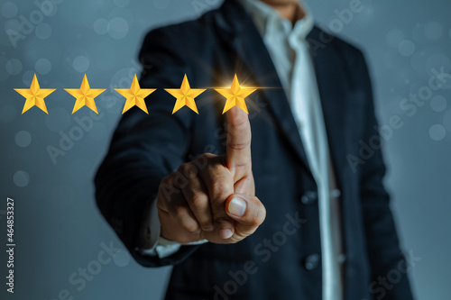A man in a business suit gives a five stars rating. Rating increase concept, classification.