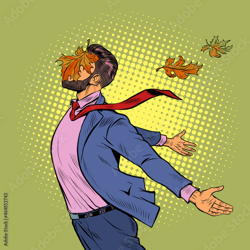 a joyful man in autumn maple leaves stands in the wind, opened his hands to the elements