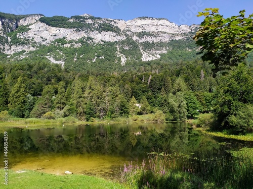 reflections and views of Lake Cei in Trentino with the Dolomites as a background