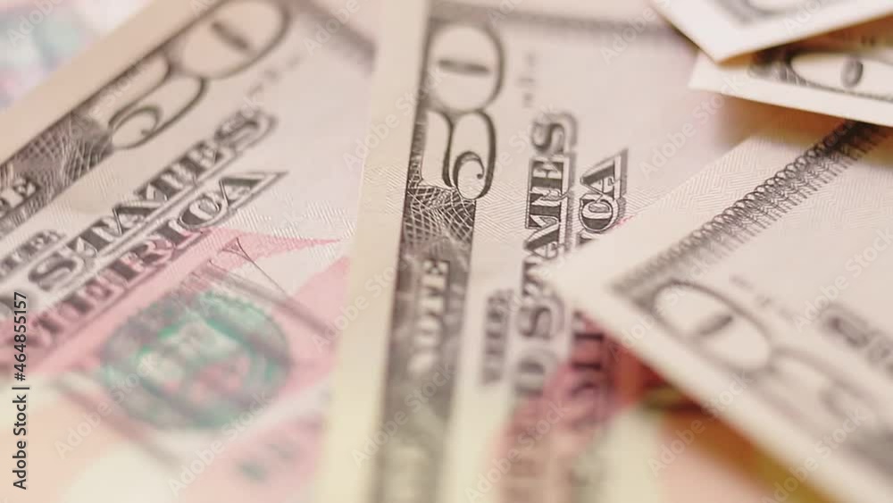 Large dollar bills spread out on the table rotate in a circle. Large dollar bills spread out on the table rotate in a circle.