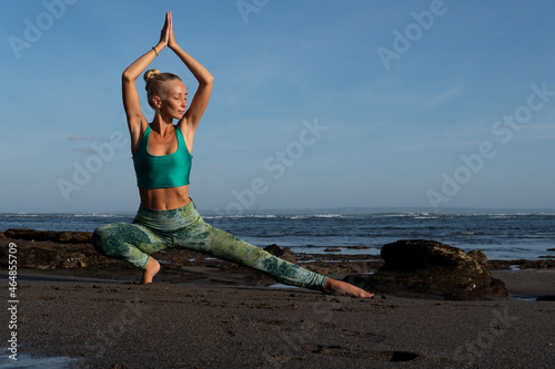 beautiful woman doing yoga on the beach