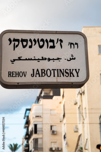 Urban city navigation street name sign, crossroad corner Jabotinsky in Tel Aviv, Israel photo