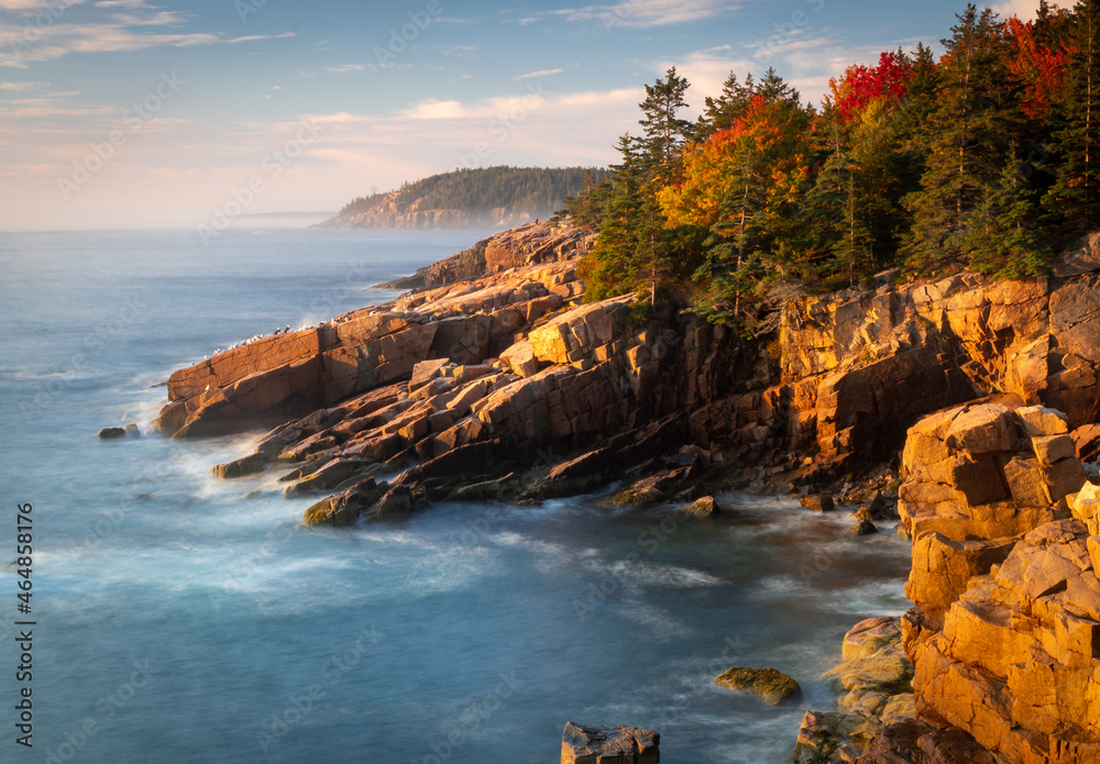 Acadia National Park, ME - USA - Oct. 13, 2021: Horizontal view of sunrise at Newport Cove in Acadia National Park in Maine. Golden hour view of the coast line and forest.