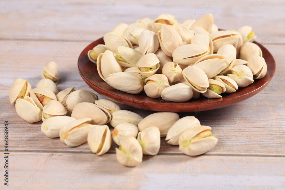 The pistachios are on the wooden board