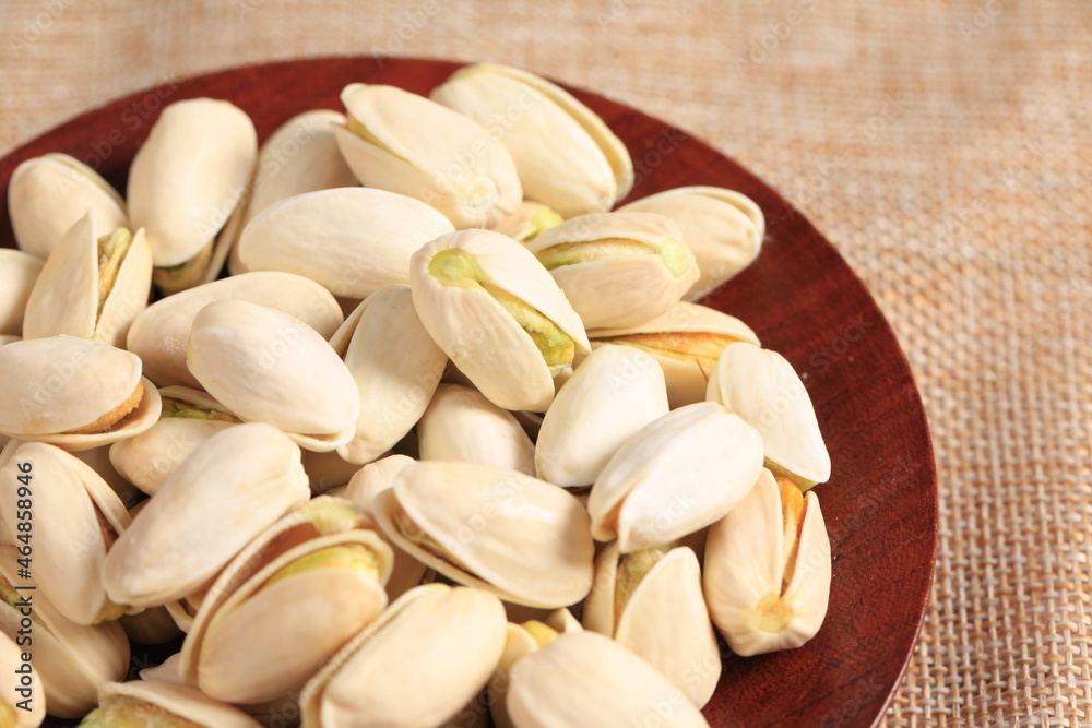 The pistachios are on the wooden board