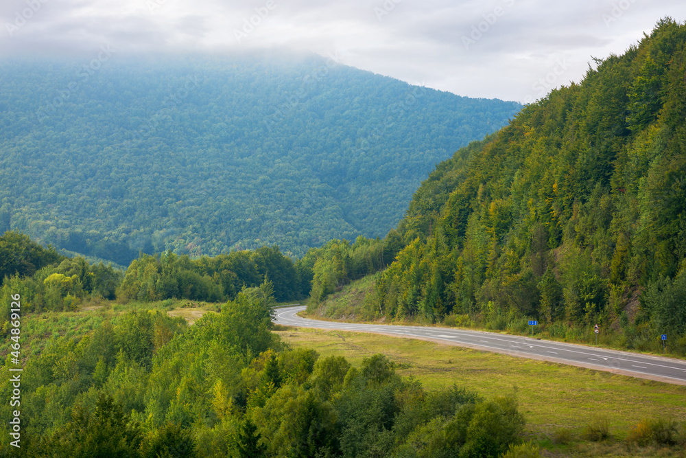 mountain road through countryside on a cloudy morning. beautiful landscape in september