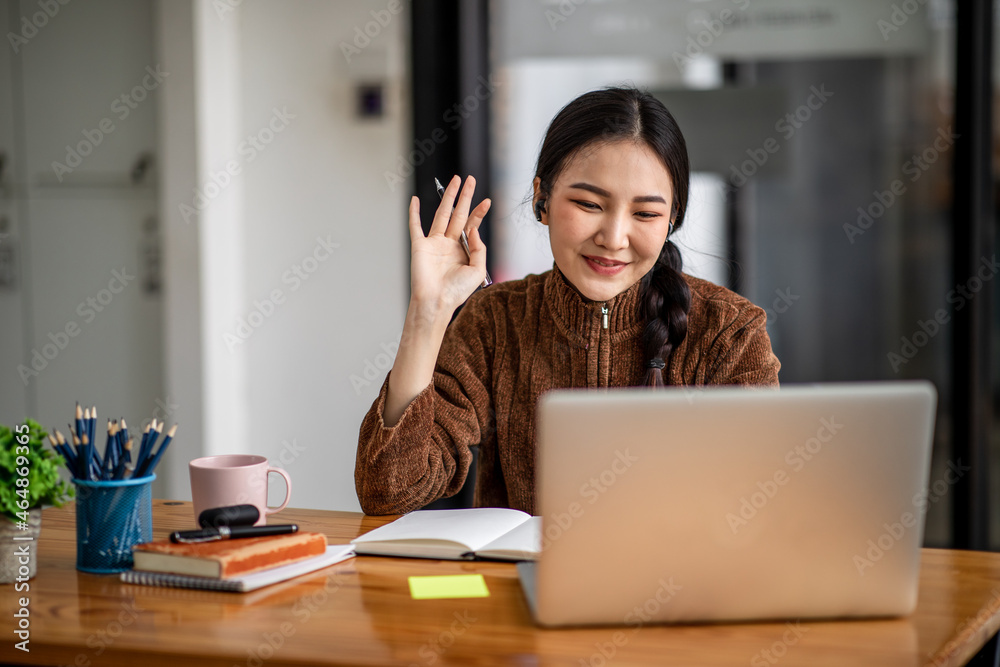Young attractive university student using a laptop computer, studying online at home. Cheerful caucasian asian woman writes notes, planning working process, sitting at home. Exam preparation. Young attractive university student using a laptop computer, studying online at home. Cheerful caucasian asian woman writes notes, planning working process, sitting at home. Exam preparation.