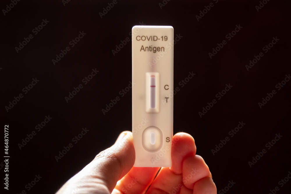 Hand holding Rapid Antigen Test kit with negative result swab COVID-19 testing. Hand holding Rapid Antigen Test kit with negative result swab COVID-19 testing.